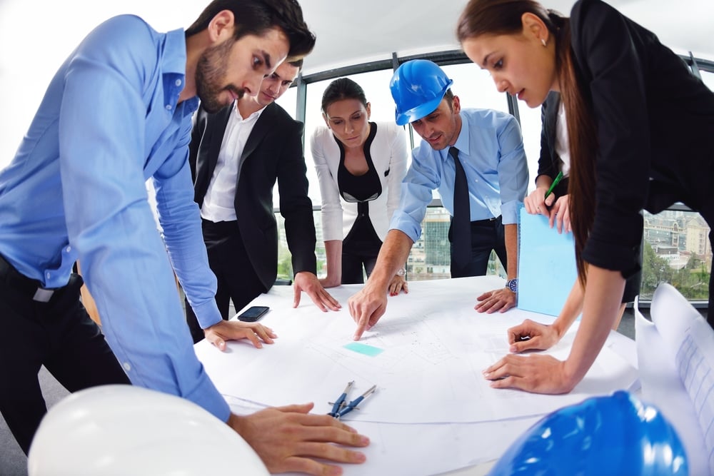 business people group on meeting and presentation  in bright modern office with construction engineer architect and worker looking building model and blueprint planbleprint plans