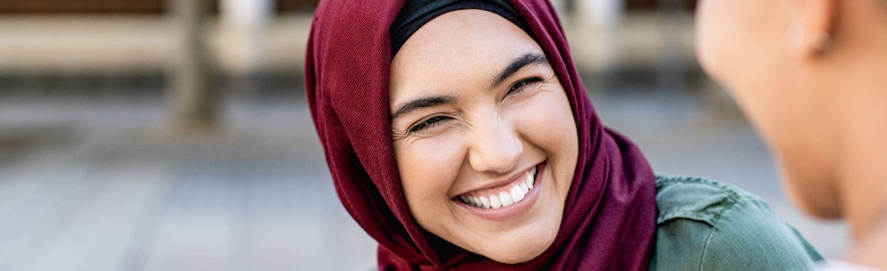LP_Header-1748x534-muslim-woman-smiling-hijab-conversing-with-coworker-outside