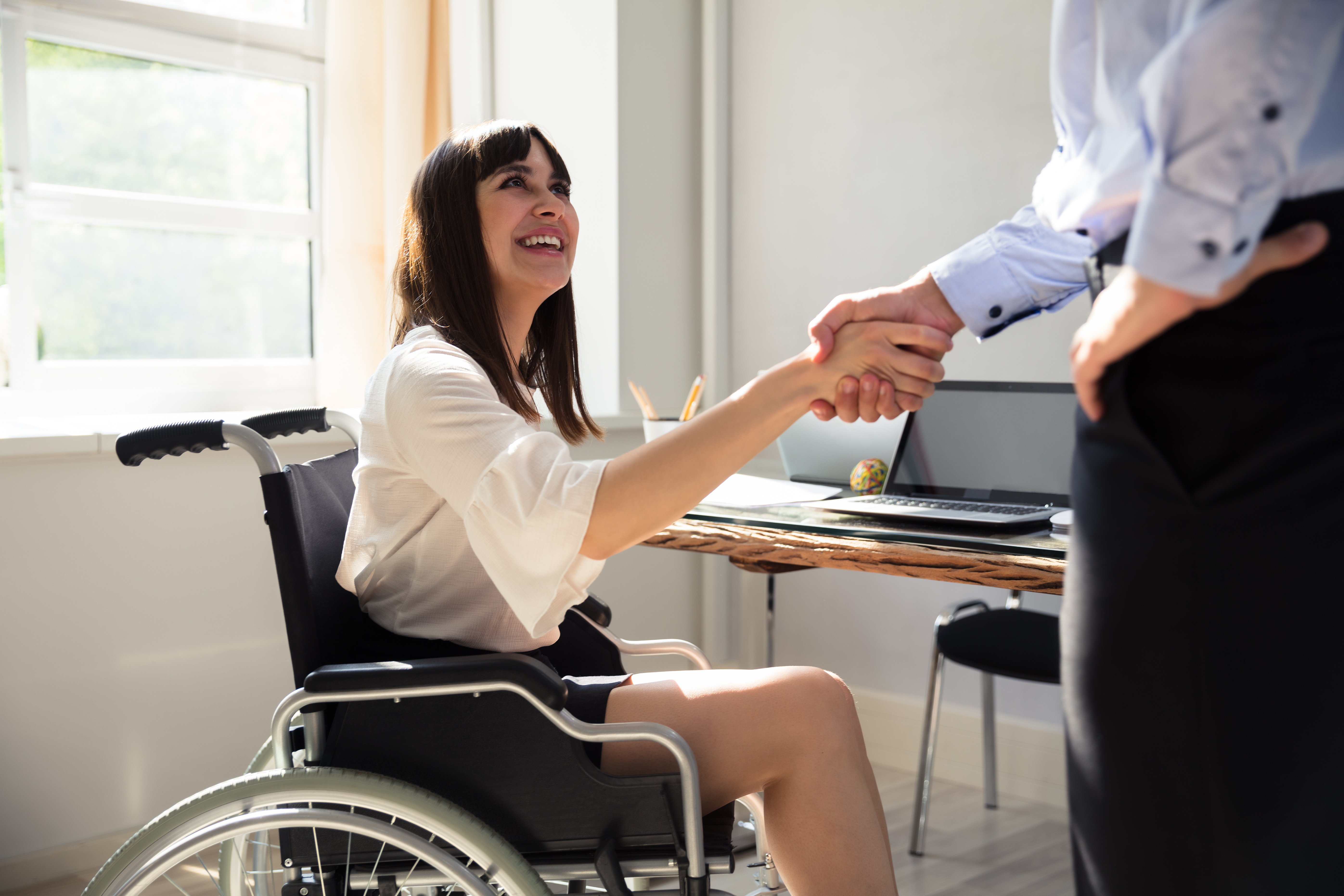 happy-female-disabled-business-woman-in-wheelchair-shaking-hand