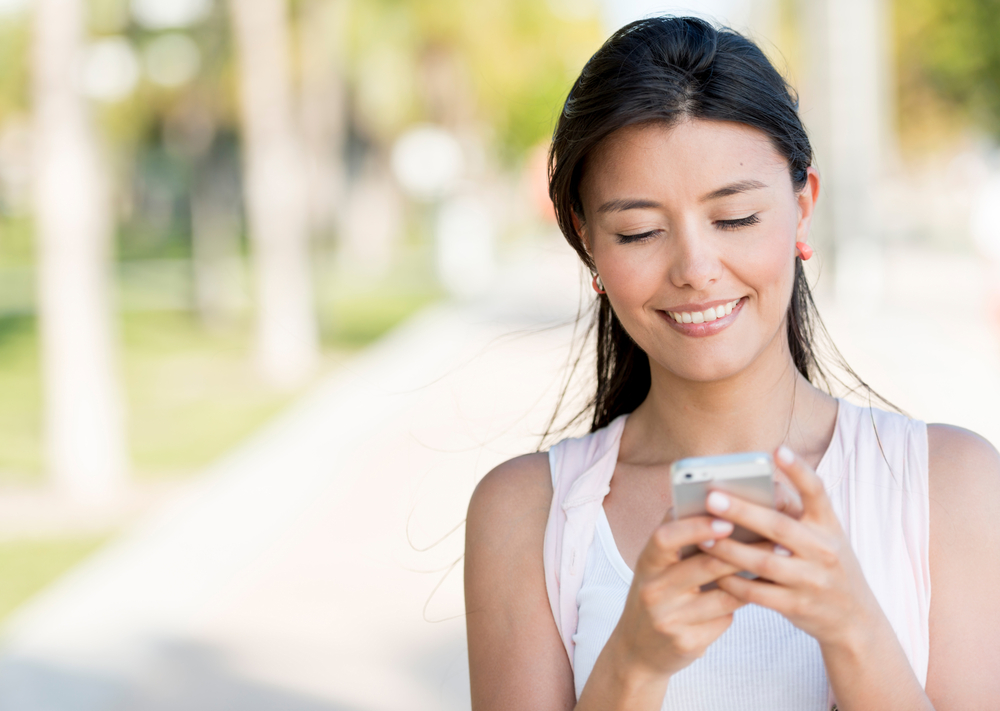 Portrait of a woman sending text message from her phone-1