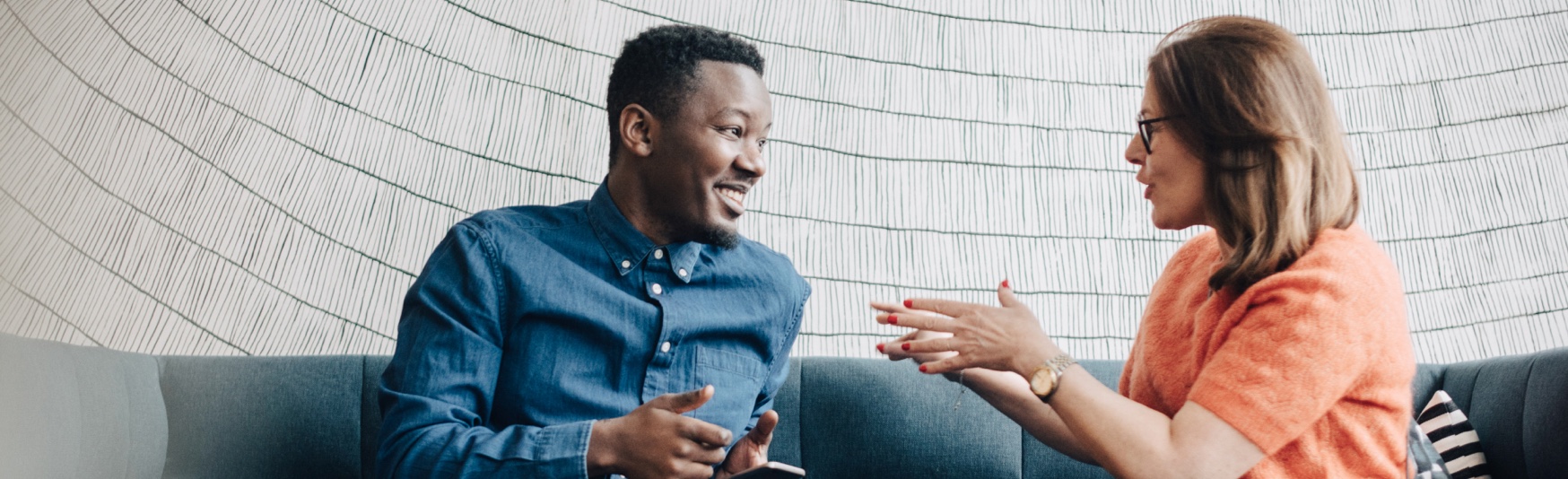 LP_Header-1748x534-white-woman-black-african-american-man-conversation-couch-business-meeting-smiling